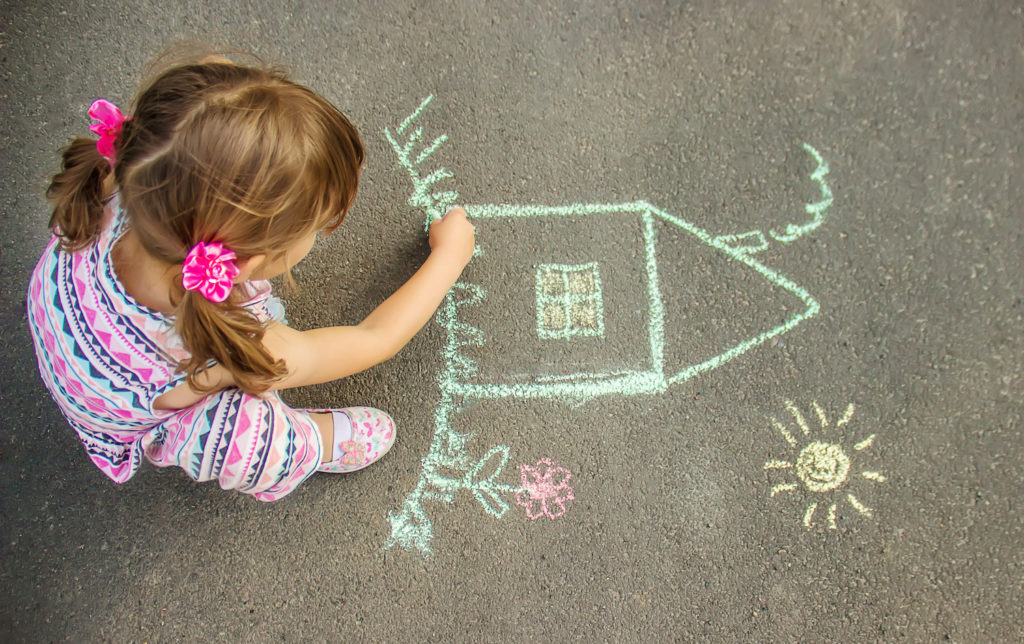 young girl making an art on street floor