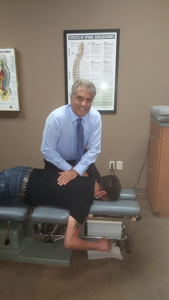 Dr. Mark Elliott, spinal adjustment on patient